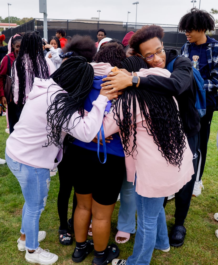 Dylan Williams (right) joins in a hug to comfort those moved by the balloon release for Mason.