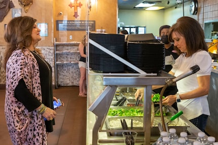 Baker's Ribs co-owner DeeAnna Krier (right) serves a plate of food for customer Debra Camp.