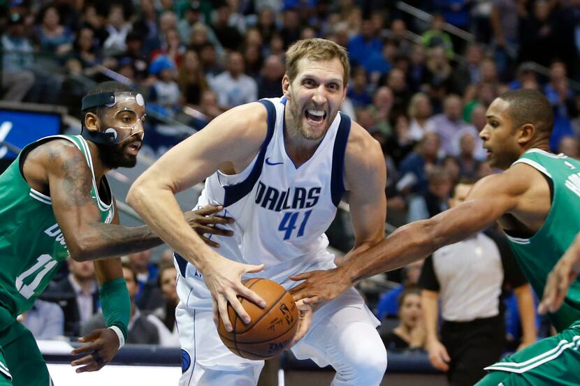 The Dallas Mavericks' Dirk Nowitzki (41) drives between the Boston Celtics' Kyrie Irving...