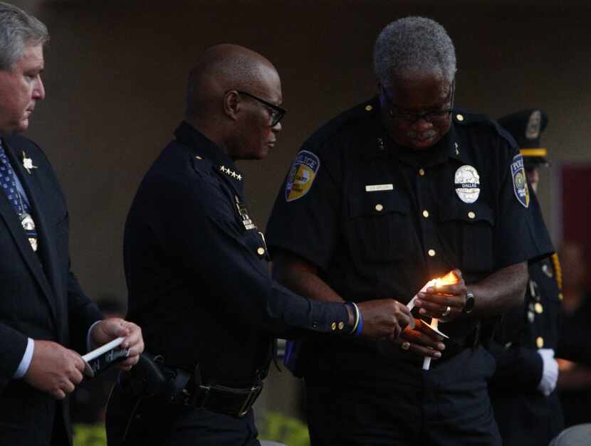 Dallas Area Rapid Transit Police Chief James Spiller (right) lights Chief David Brown's...