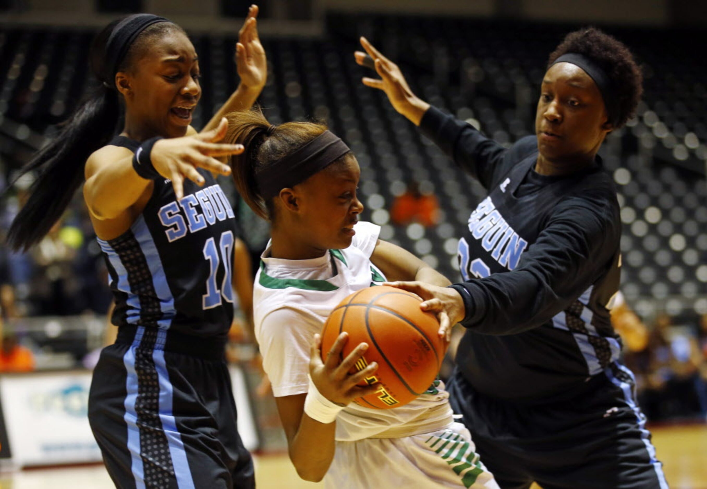 Bryan Adams' Alexxus Gilbert (12) tries to escape the pressure by Arlington Seguin's Khilyn...