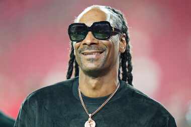 FILE - Entertainer Snoop Dogg walks on the field before an NFL football game between the...