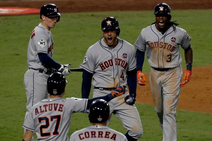 The Houston Astros' George Springer, middle, celebrates his two-run home run in the 11th...