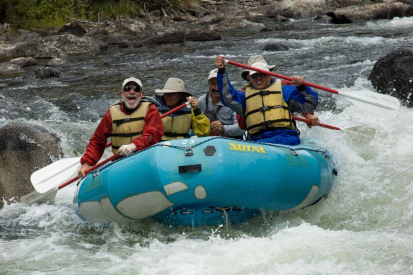 Grinning river rats splash through Toilet Bowl Rapid on the Taylor River southeast of...