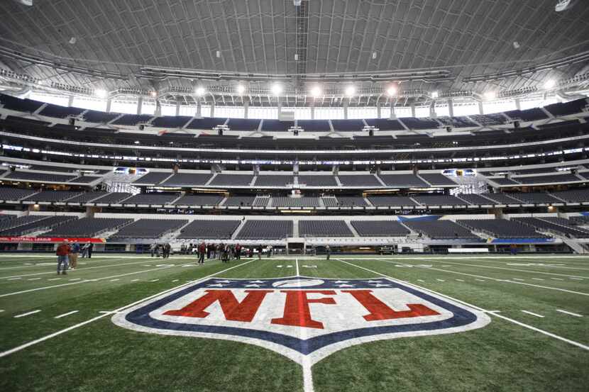 FILE - The NFL logo, painted at midfield, is pictured above at AT&T Stadium in Arlington on...