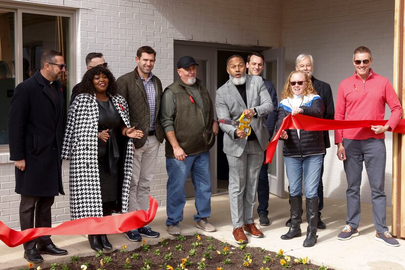 President and CEO Traswell Livingston (center right) reacts after a ribbon cutting ceremony...