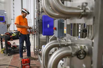 Angel Rodrigue works on a processor that sanitizes products at SunOpta’s manufacturing plant...