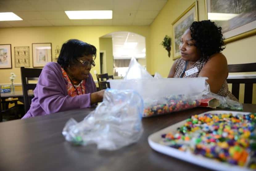 Lucretia Honore (right), activity assistant, helps Mattie Richardson sort beads at Friends...