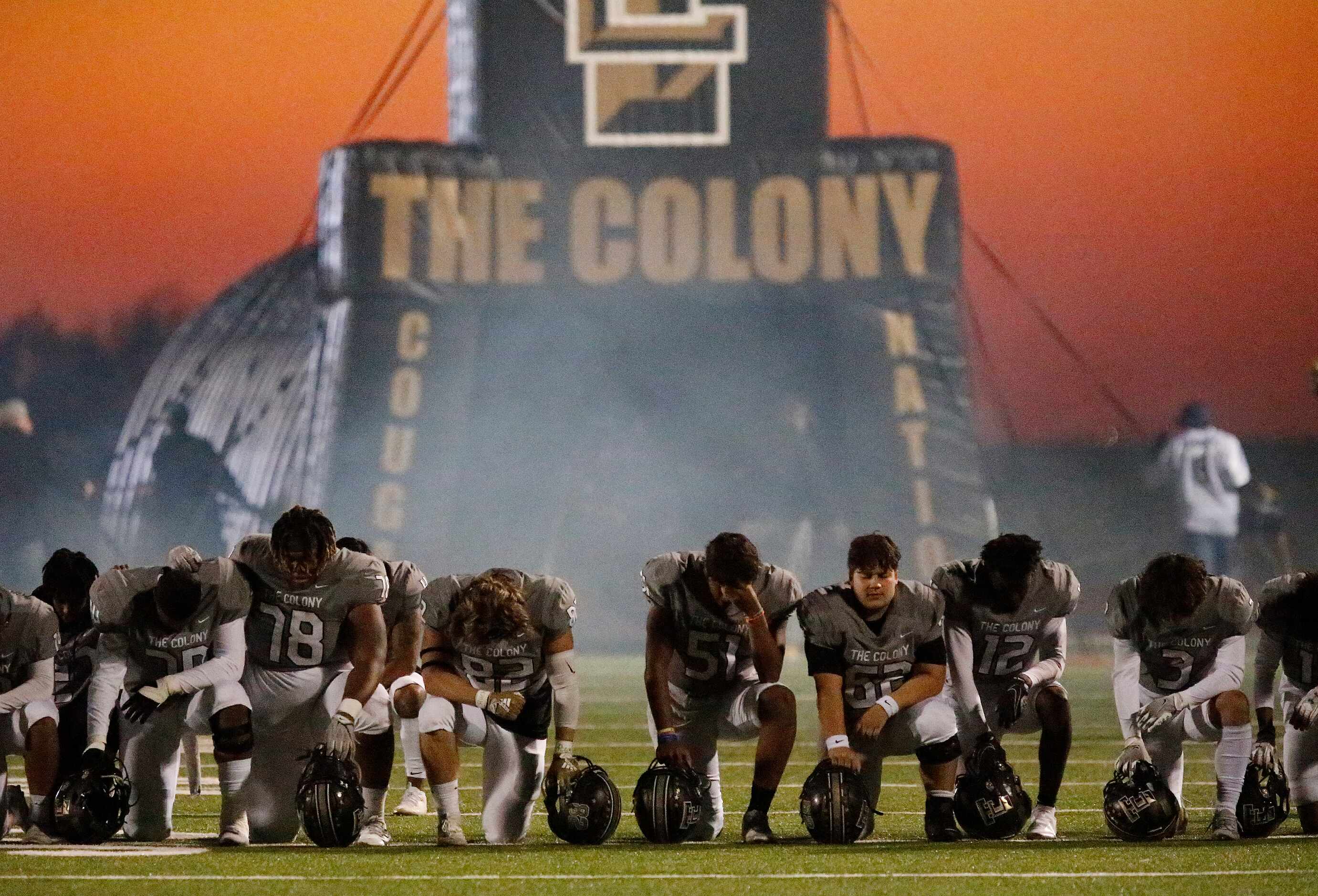 The Colony High School football team says a prayer on the field before kickoff as Reedy High...
