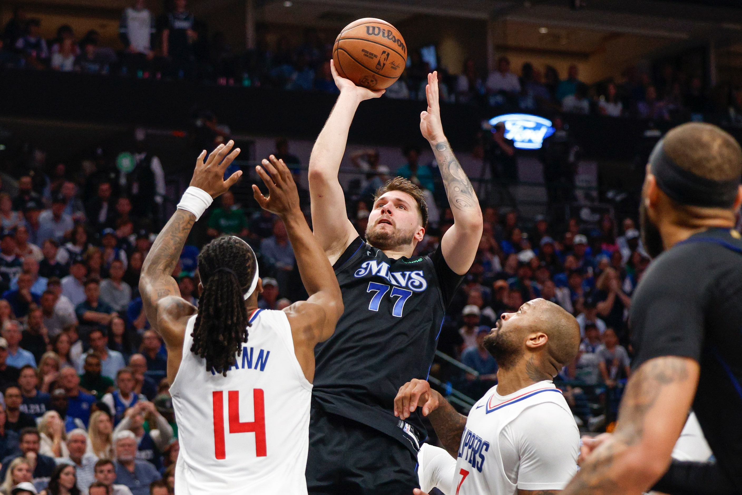 Dallas Mavericks guard Luka Doncic (77) shoots over LA Clippers guard Terance Mann (14)...