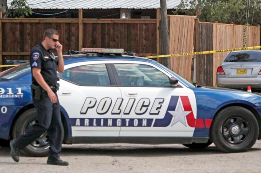 An Arlington police officer is pictured at a crime scene last August. After two fatal car...