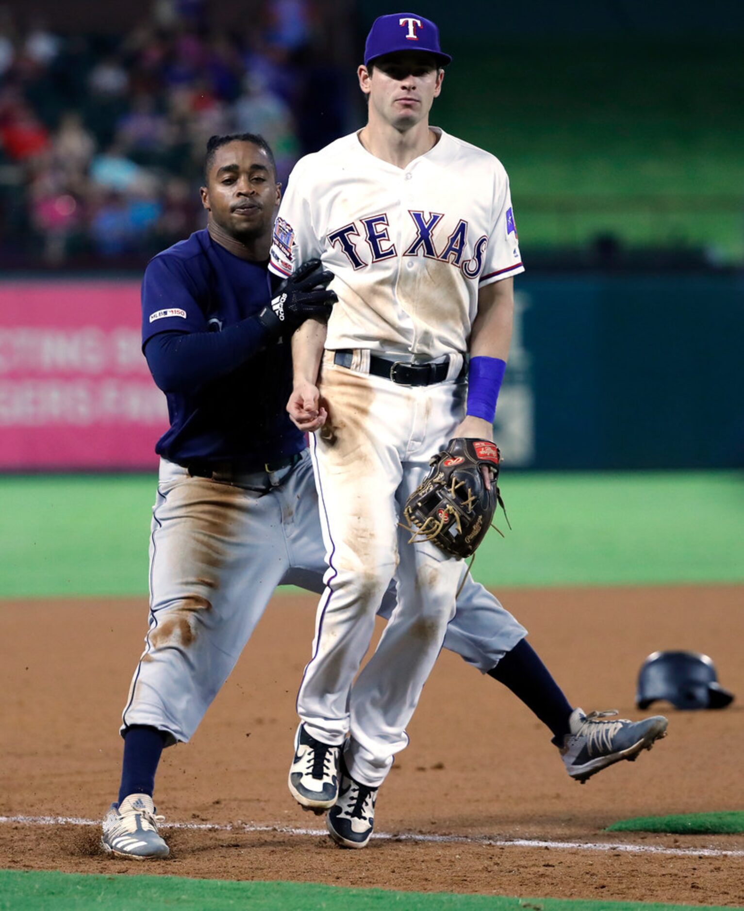 Seattle Mariners' Mallex Smith, left, runs in to Texas Rangers third baseman Nick Solak as...