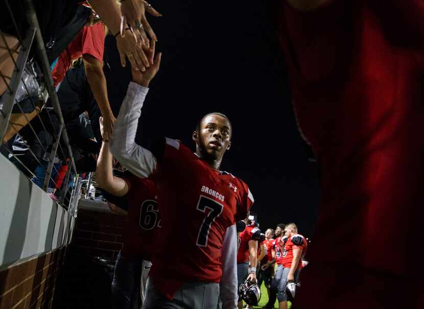 Mansfield Legacy quarterback Andrew Smith (7) high-fives fans after a 39-7 win over Crowley...