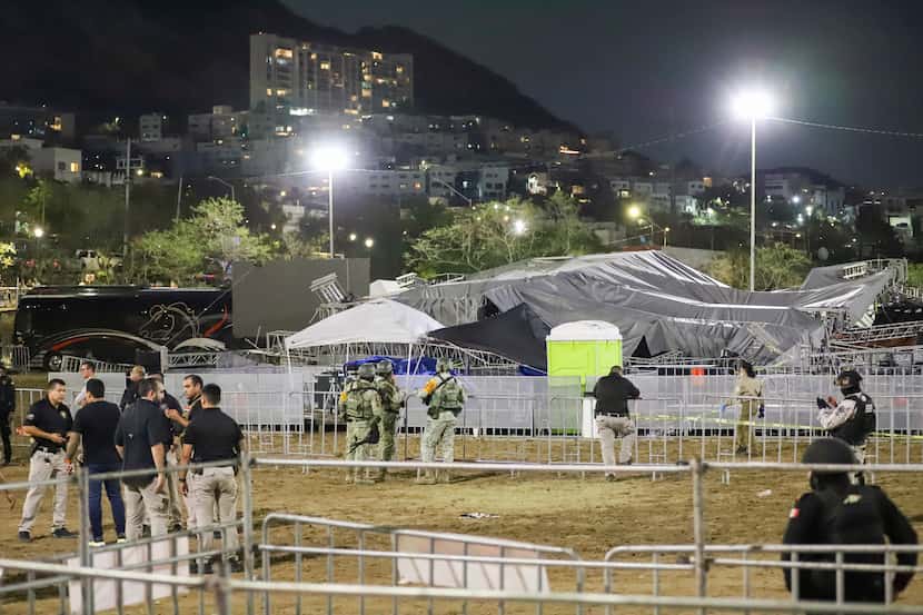 Fuerzas de seguridad rodean un escenario que se derrumbó debido al viento en un acto al que...