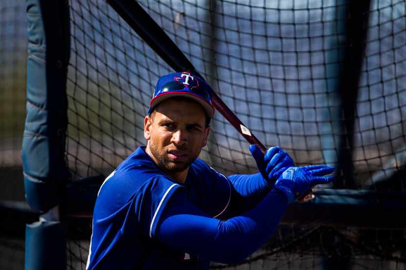 Texas Rangers first baseman James Loney (18) bats during a spring training workout at the...
