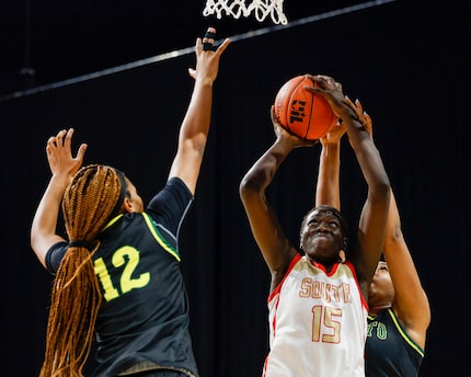 South Grand Prairie center Adhel Tac (15) attempts a layup in between DeSoto guard Jiya...