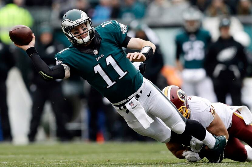 Philadelphia Eagles' Carson Wentz, left, is tackled by Washington Redskins' Ryan Kerrigan...