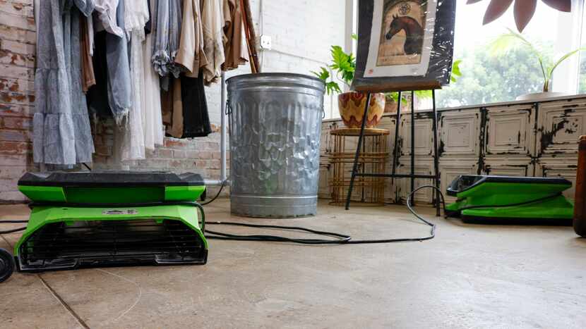 Large fans dry the floor and walls at Flea Stye the day after heavy rain brought water...