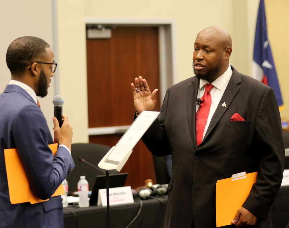 New trustee Maxie Johnson is sworn in to the Dallas ISD board by fellow trustee Justin...