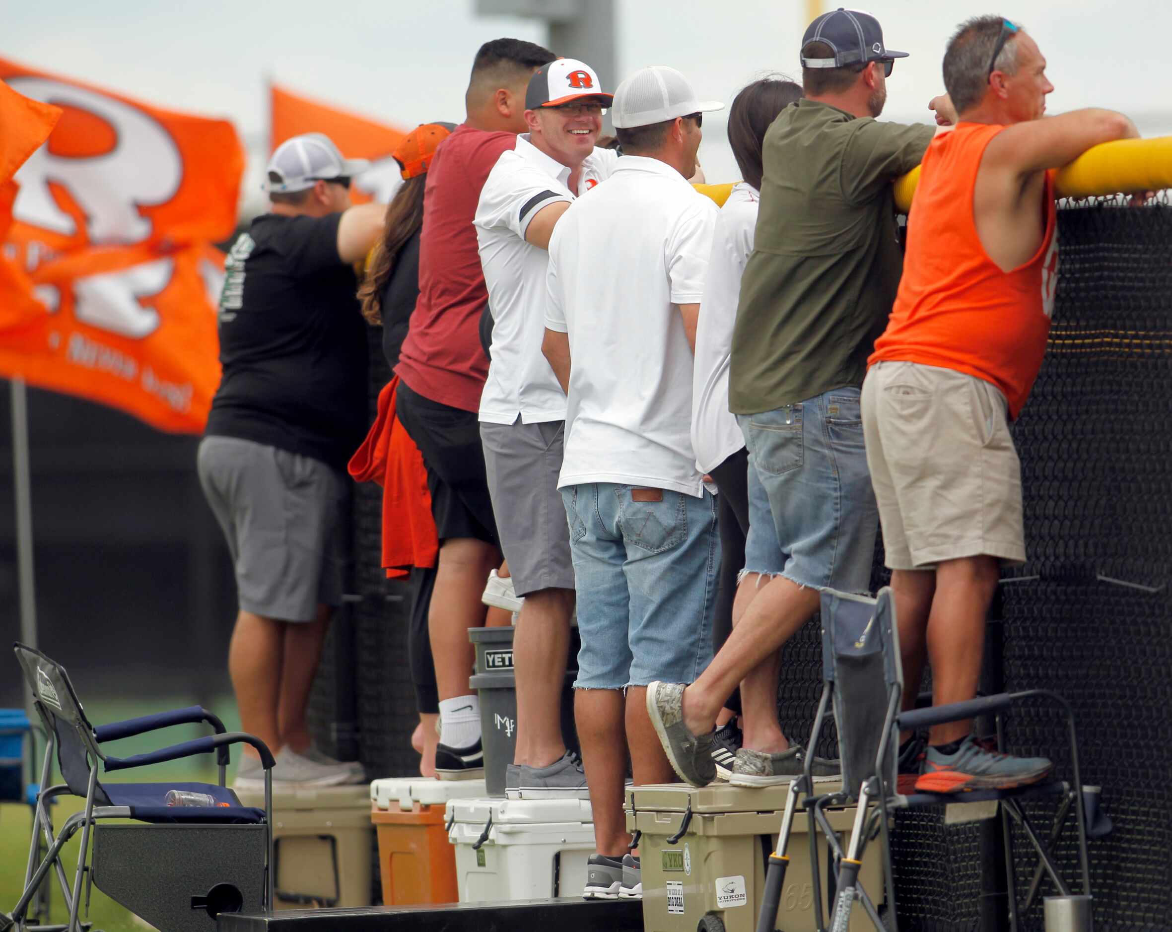 Rockwall fans stand on ice chests to elevate their view over the top of the right center...