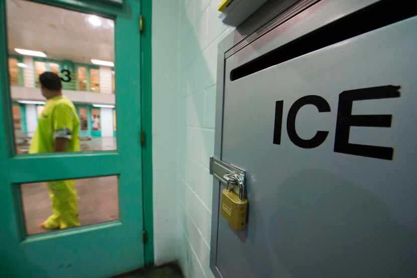 An immigration detainee stands near an US Immigration and Customs Enforcement (ICE)...