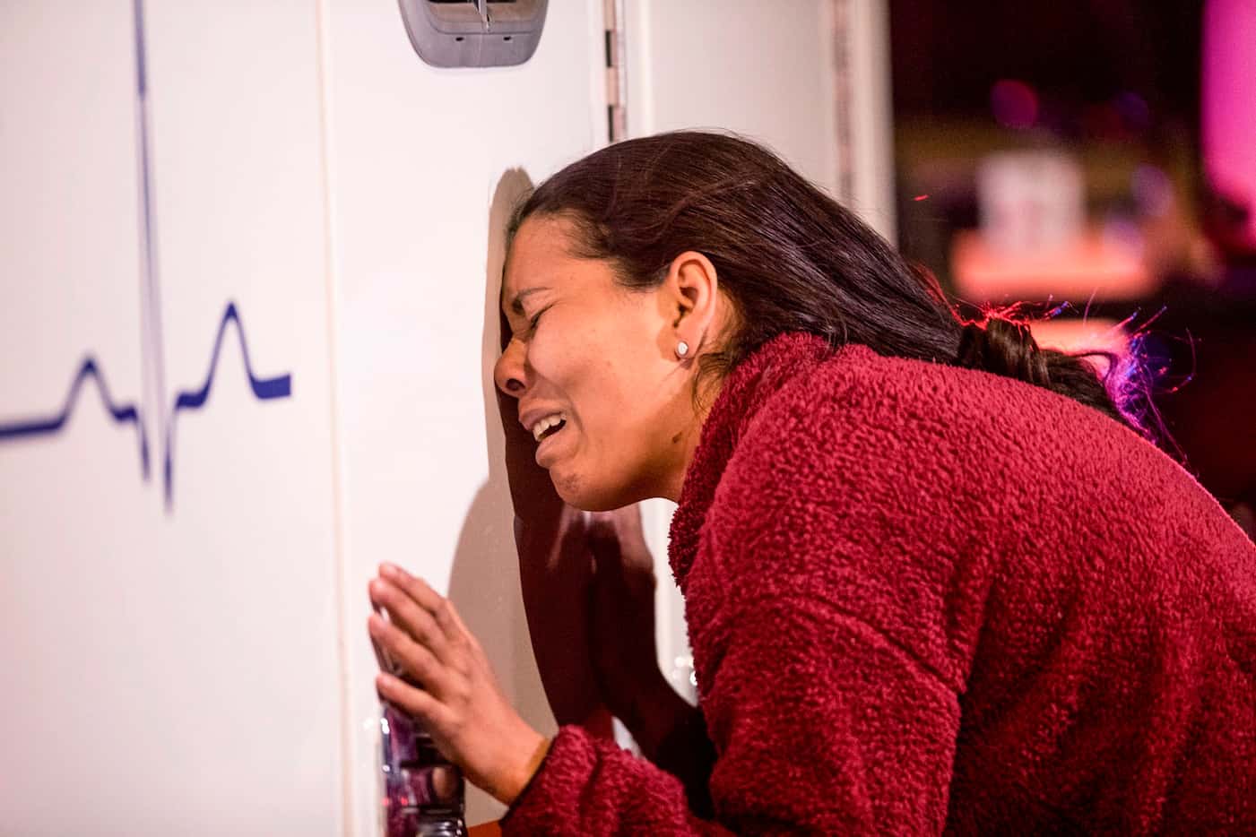 A migrant cries leaning on an ambulance as a person she knows is attended by medics after a...
