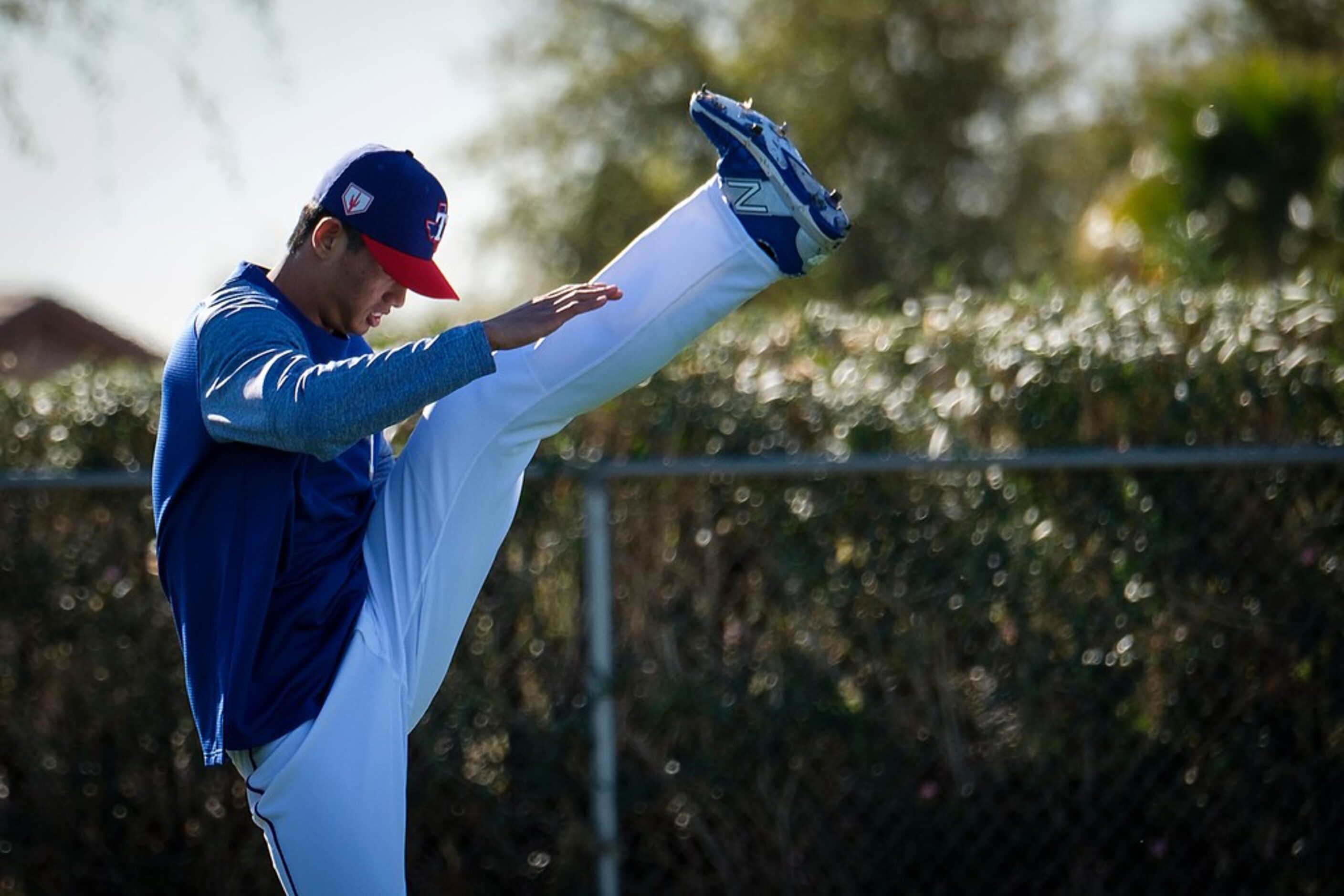 Texas Rangers pitcher Wei-Chieh Huang stretches on a conditioning field after pitchers and...