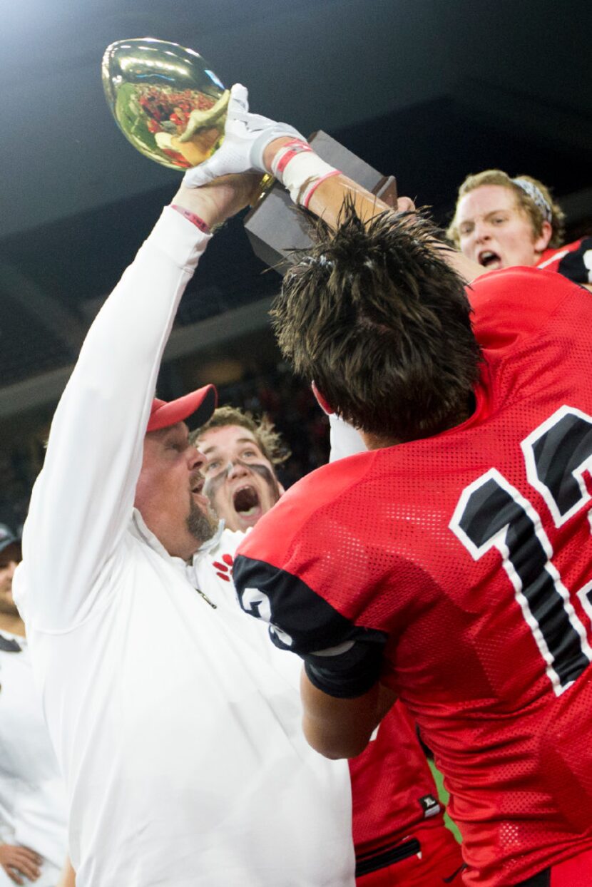 Heritage head coach Joe Willis presents the trophy to his team after the area round playoff...