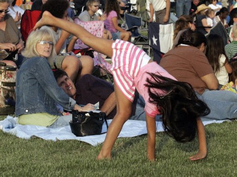 Karen and Vern Larman watch as daughter Kate turns a cartwheel before the start of the...