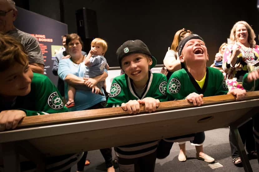 Dallas Stars fans laugh as mascot Victor E. Green tries out a new interactive reaction time...