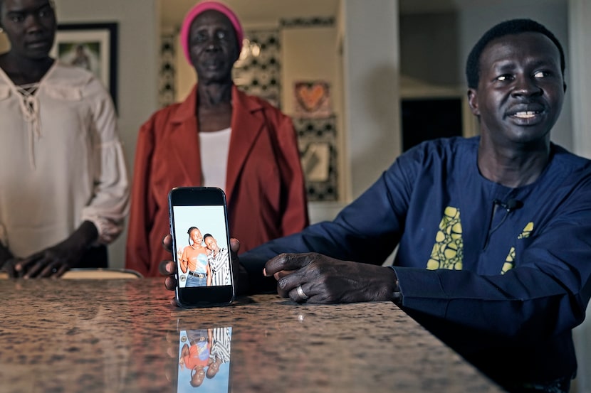 Jacob Mabil shows a cell phone photo of his nieces Nyanluak Deng (left) and Anyier Deng...