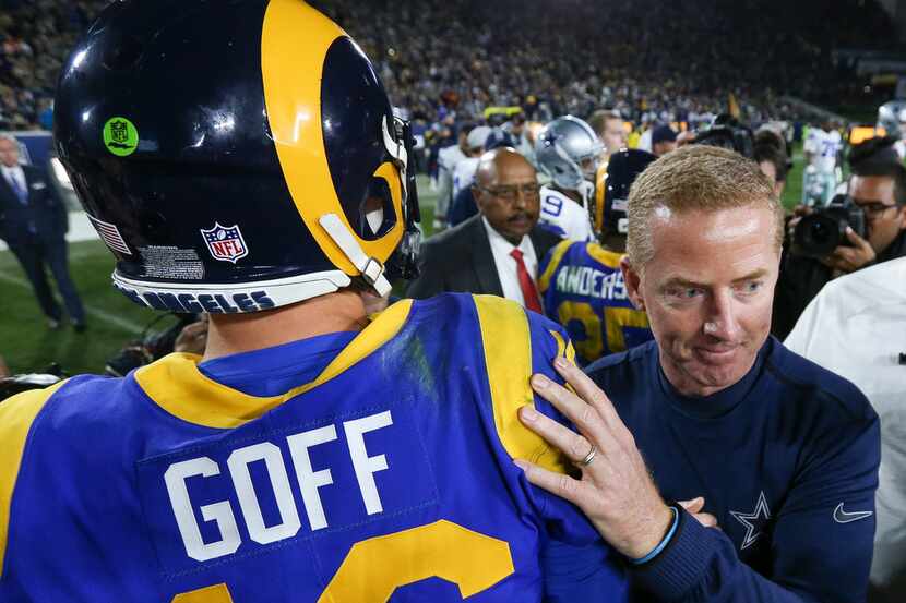 Dallas Cowboys head coach Jason Garrett embraces Los Angeles Rams quarterback Jared Goff...