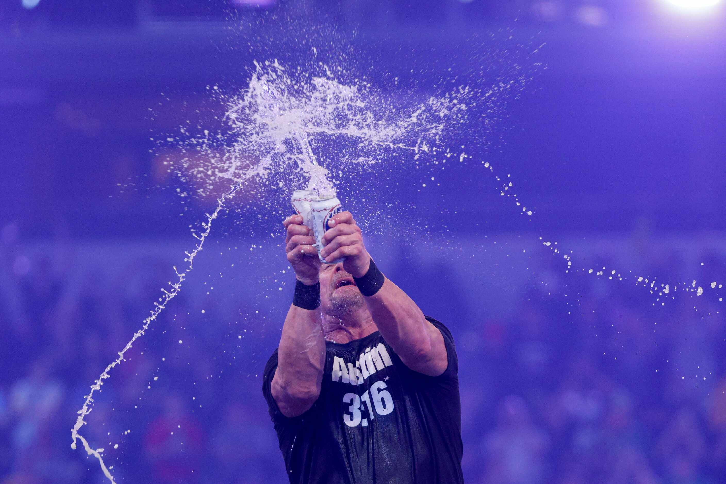 “Stone Cold” Steve Austin smashes two beers together after defeating Kevin Owens in a match...
