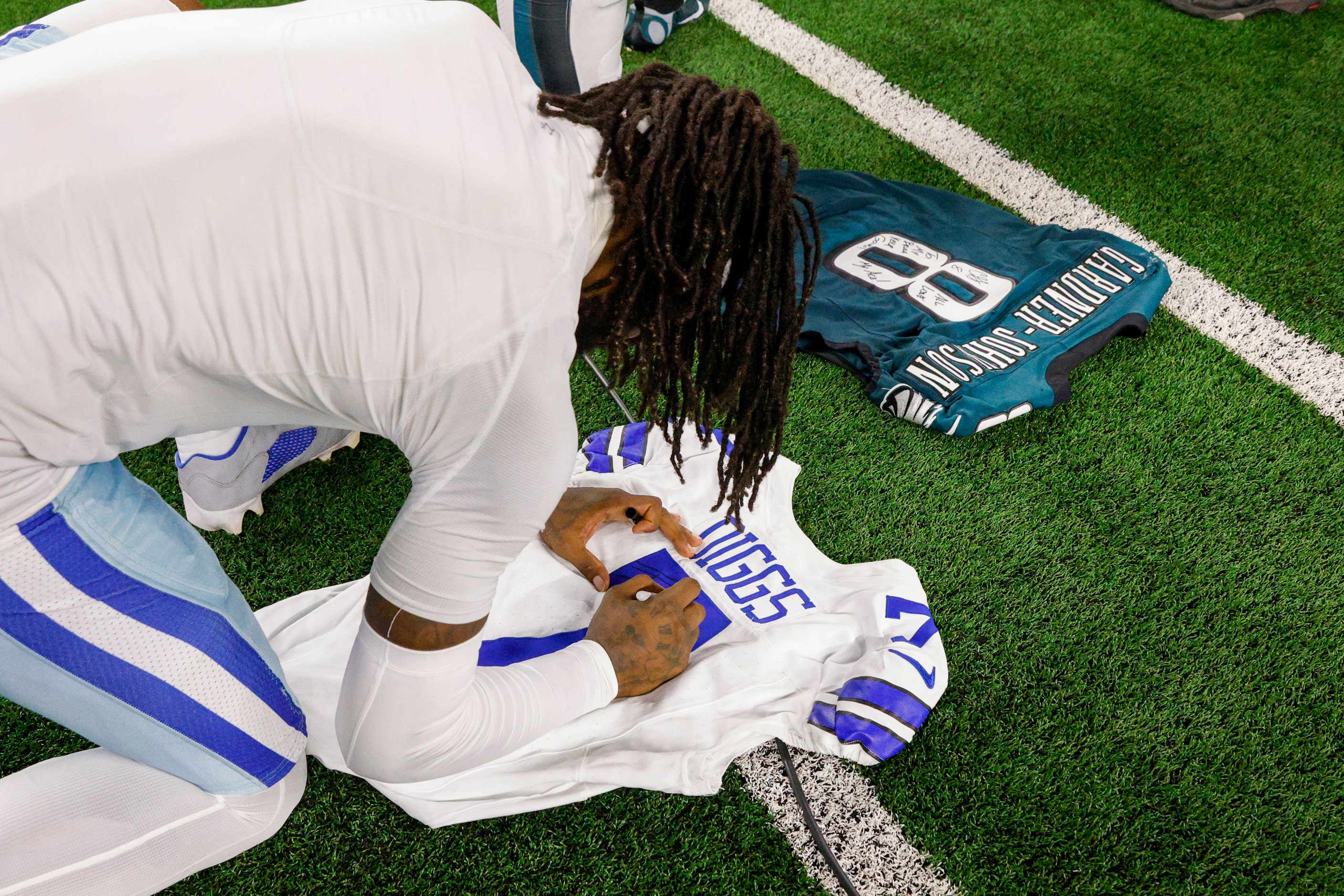 Dallas Cowboys cornerback Trevon Diggs autographs his jersey for Philadelphia Eagles safety...