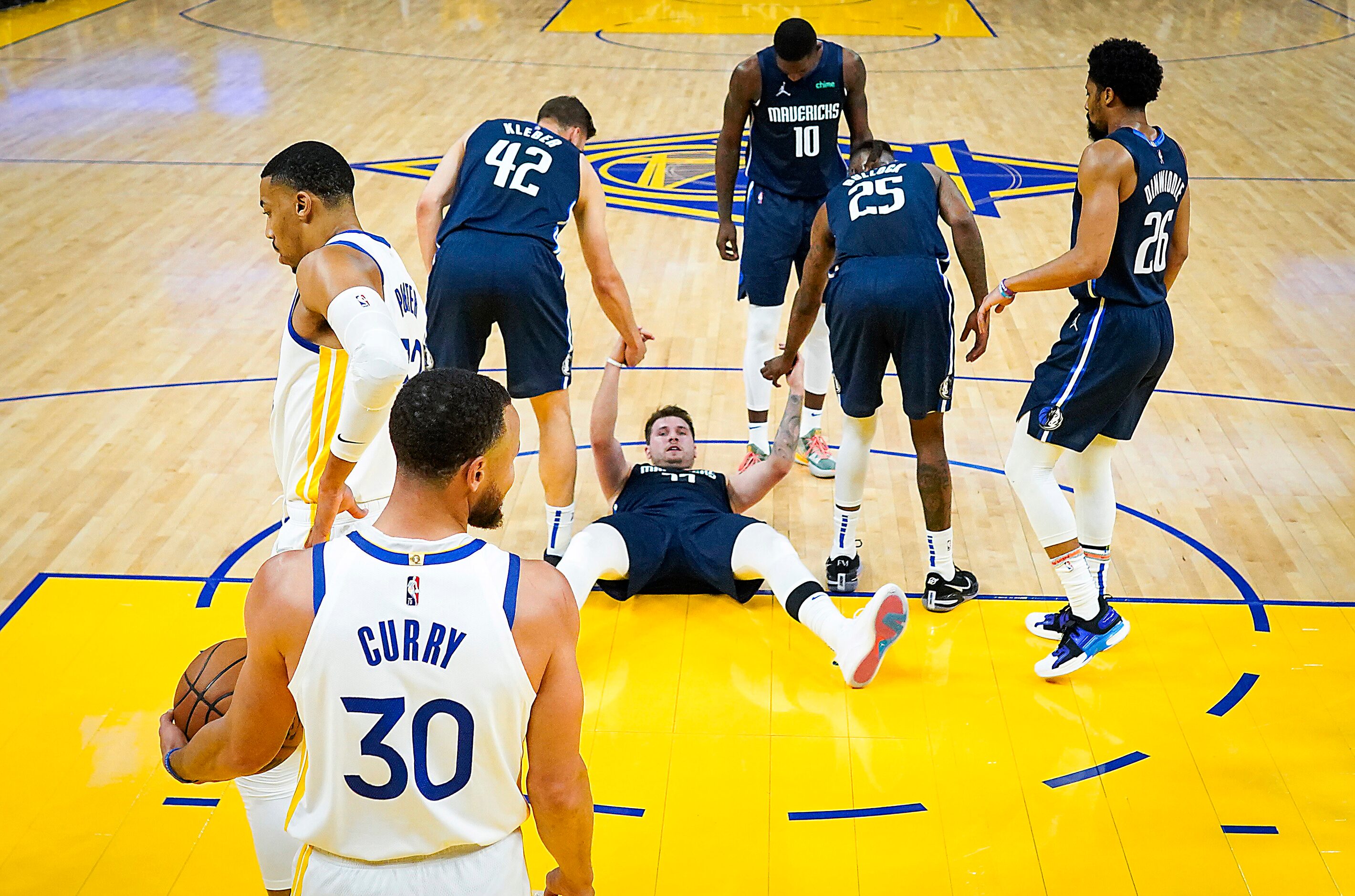 Dallas Mavericks guard Luka Doncic (77) gets a hand up after being fouled by Golden State...