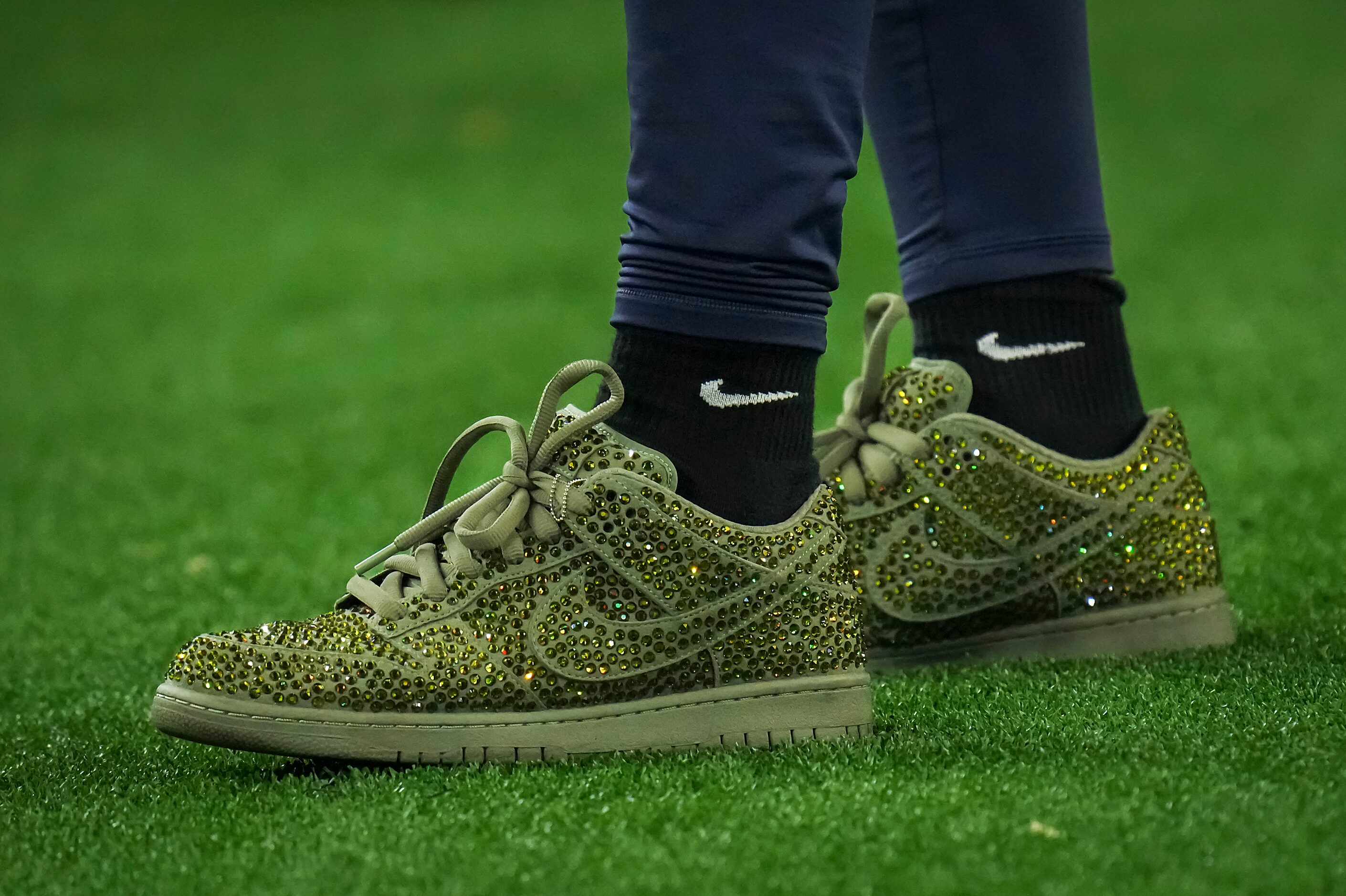 Dallas Cowboys wide receiver CeeDee Lamb wears sneakers as he watches from the sidelines...