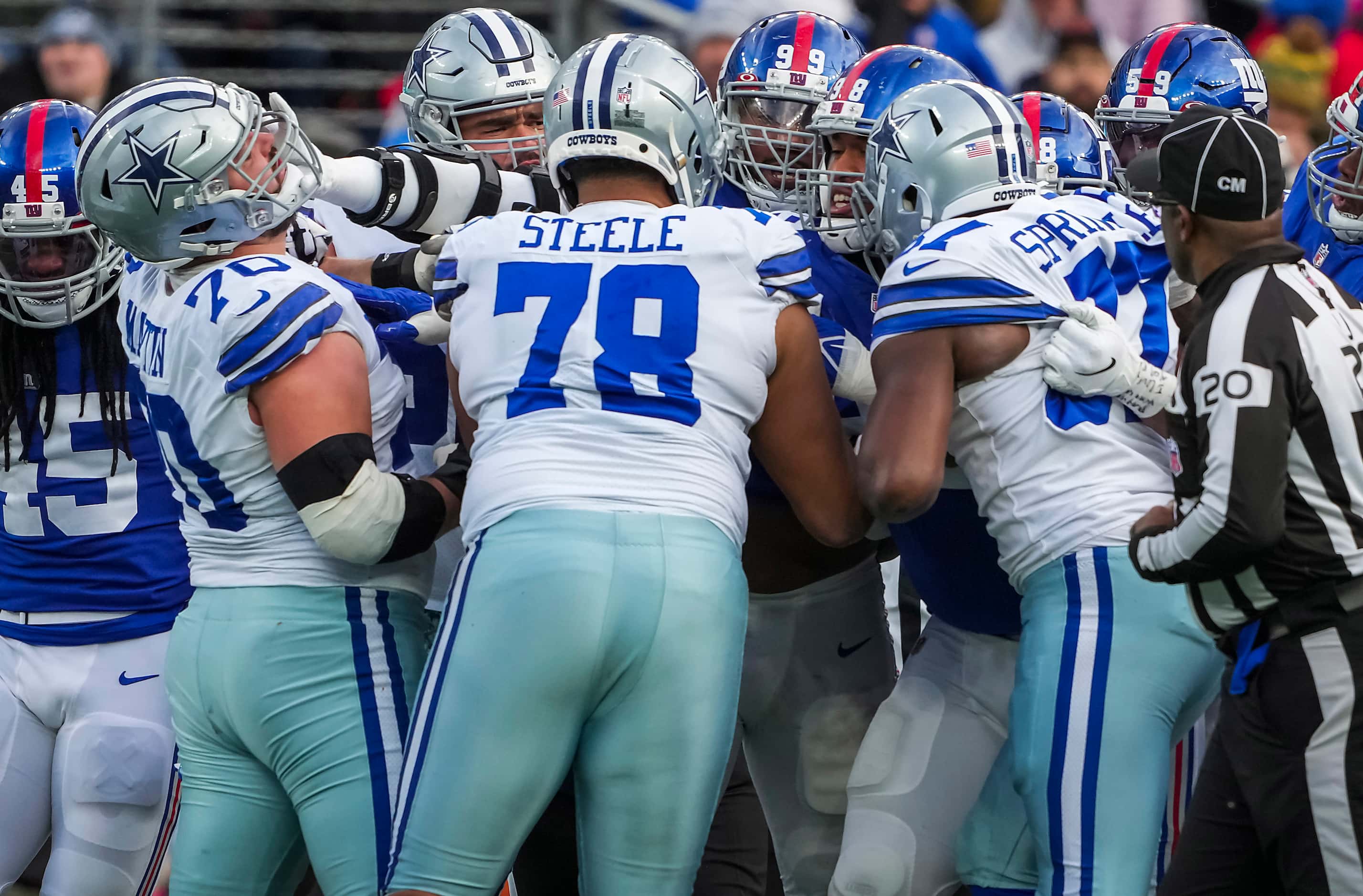 Players and officials try to seperate Dallas Cowboys guard Zack Martin (70) from New York...