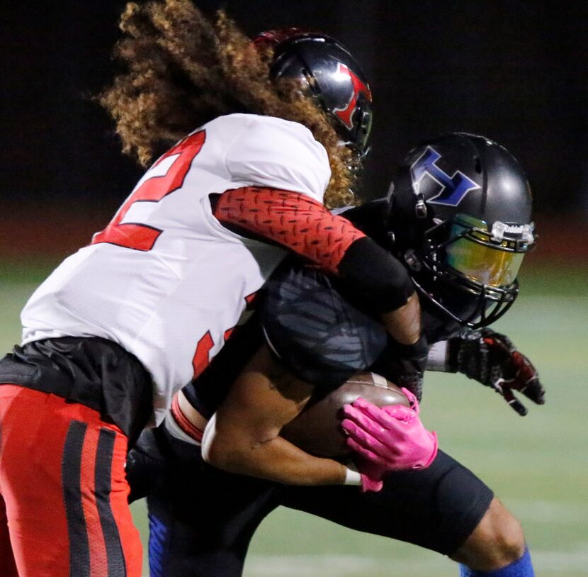 Trinity High School free safety Sebastian Tauaalo (32) brings down Hebron High School wide...