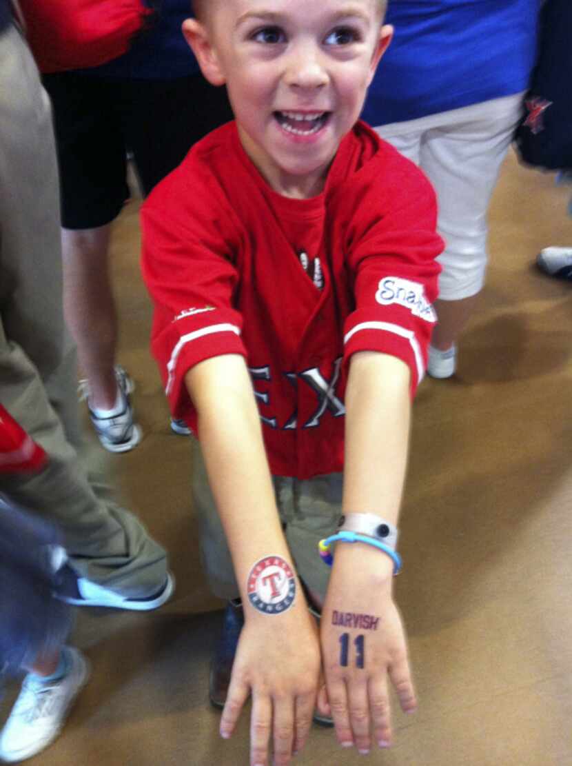 Slade Thompson of Dallas shows off his temporary Texas Rangers and Yu Darvish tattoos that...