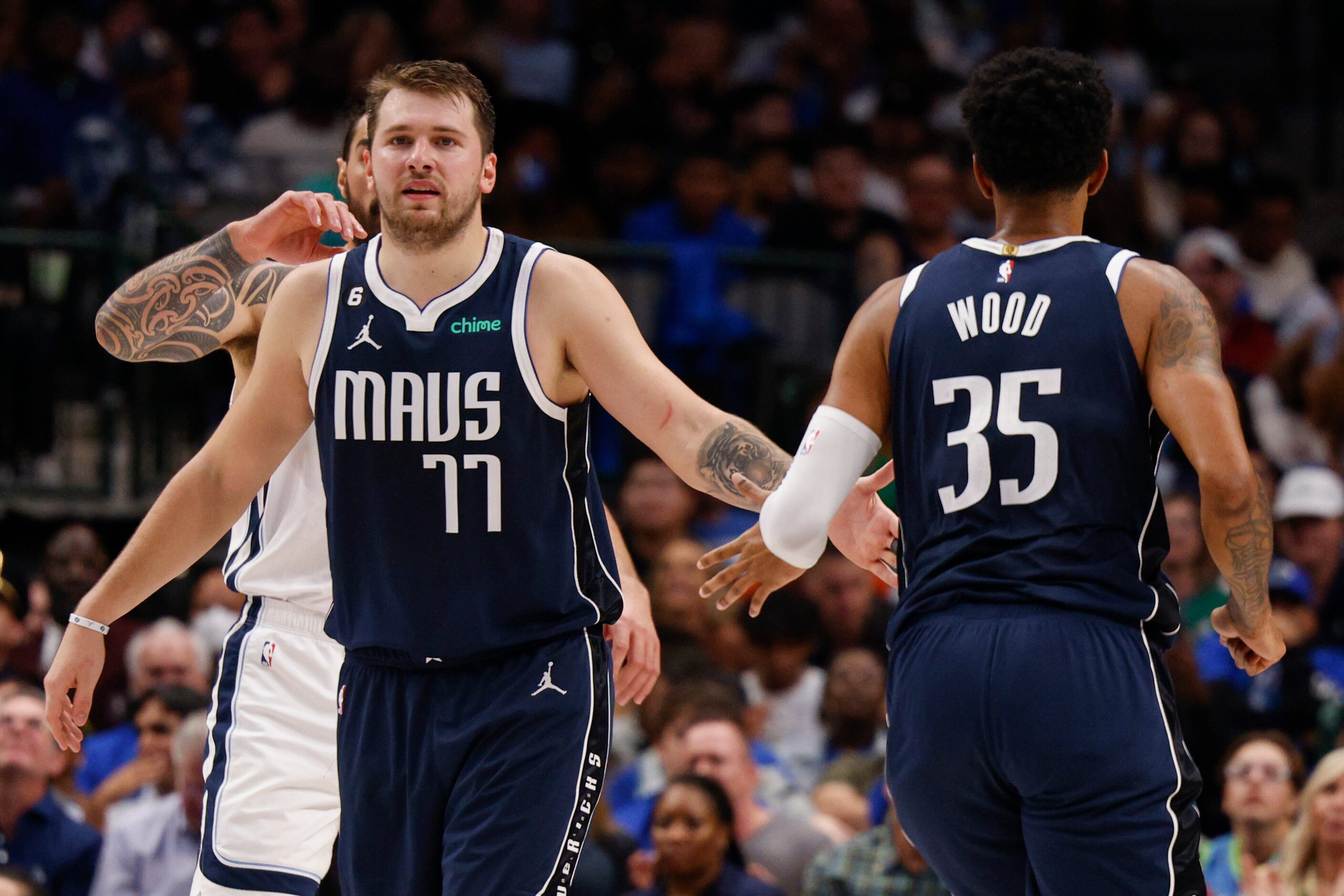 Dallas Mavericks guard Luka Doncic (77) high-fives center Christian Wood (35) during the...