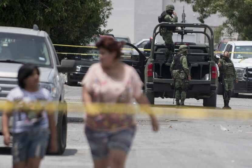 Mexican soldiers stand by at the scene where an armed group confronted the police resulting...