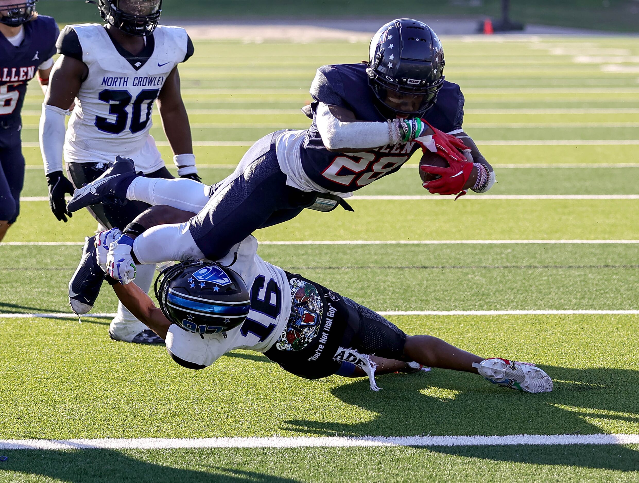 Allen running back Amir McDowell (28) divers over North Crowley defenisve back Hameef Bilal...