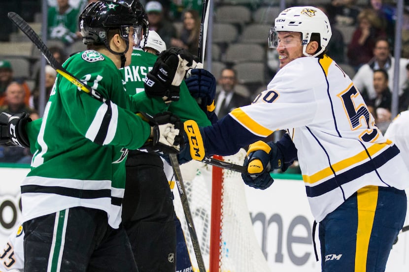 Dallas Stars left wing Antoine Roussel (21) gets hit with a stick by Nashville Predators...