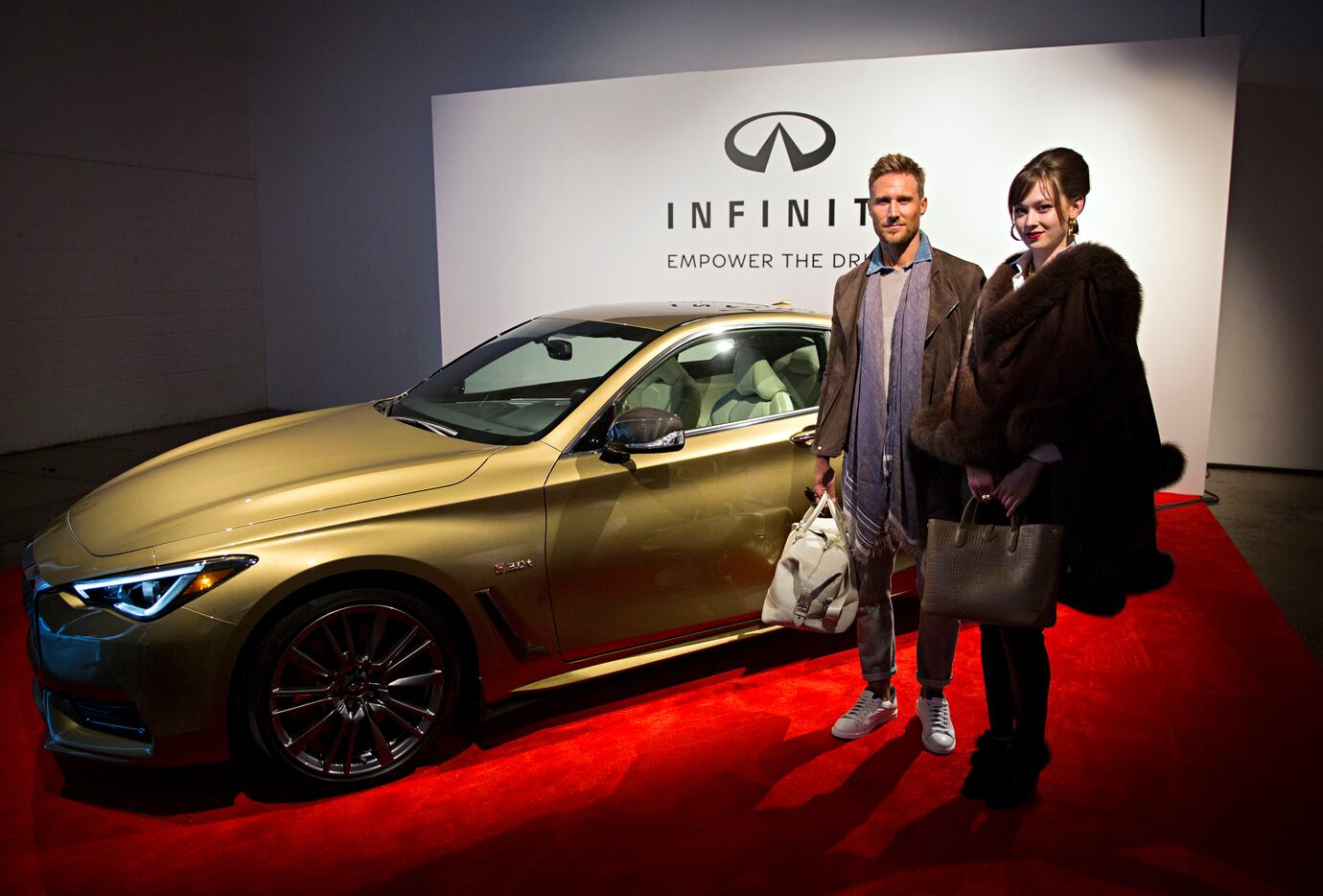 Models Chad Rohde (left) and Maegan Valenta stand in front of a Infiniti Q60 Neiman Marcus...