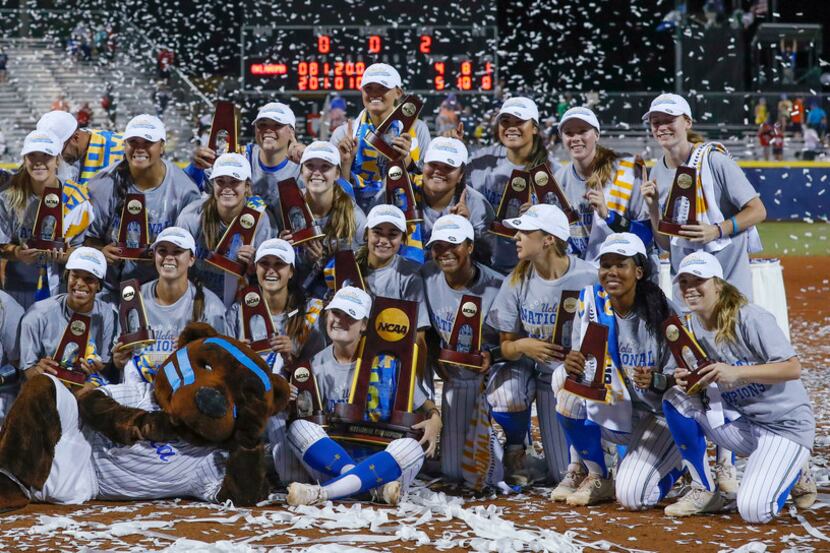The UCLA team poses for photos after defeating Oklahoma in the NCAA softball Women's College...