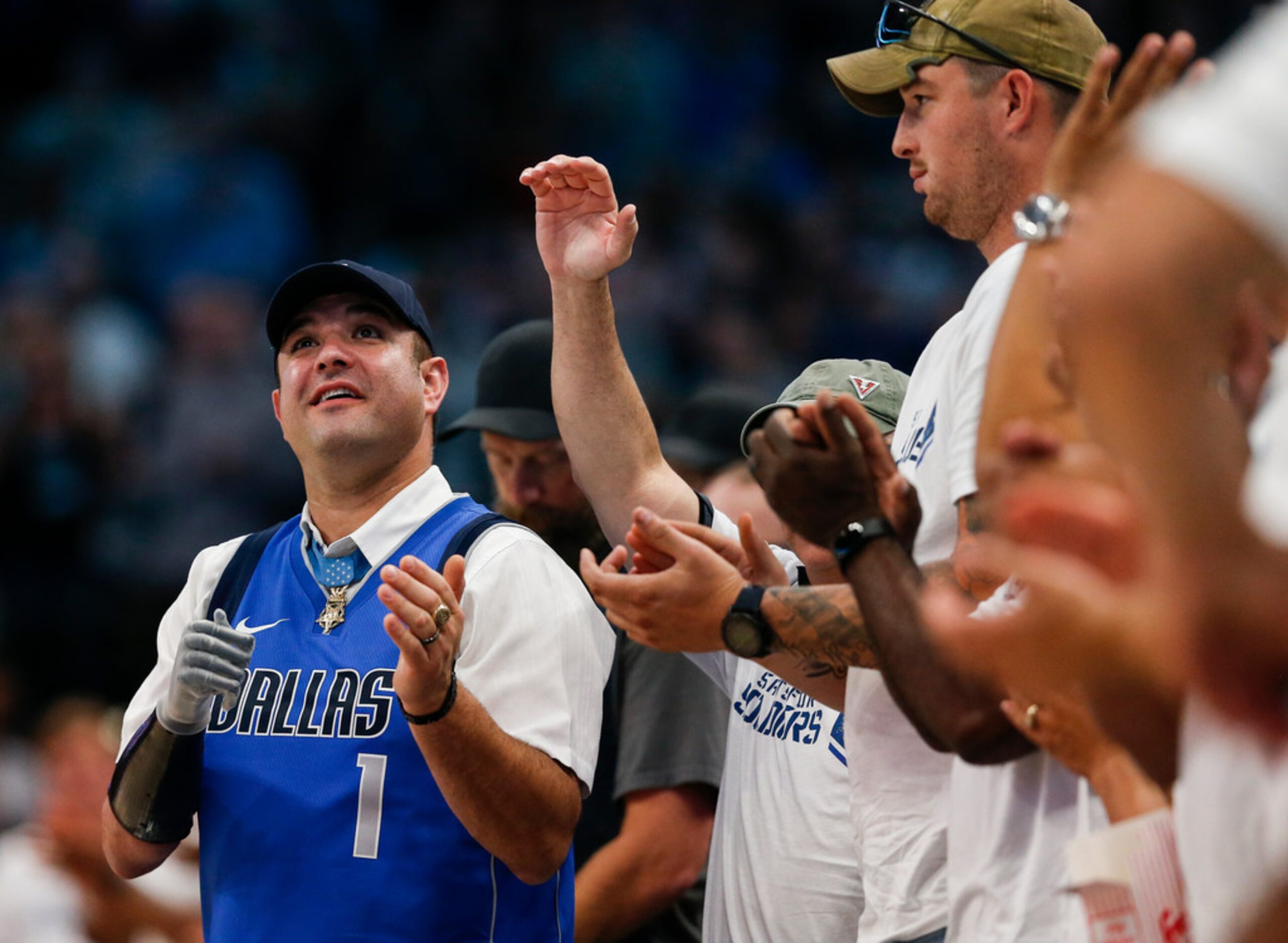 Veterans and members of the armed forces fill court-side seats for an NBA game between the...