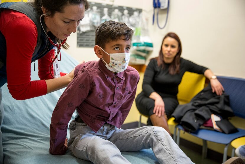 A doctor examines Christopher Serrano, 10, who is covered by the Children's Health Insurance...