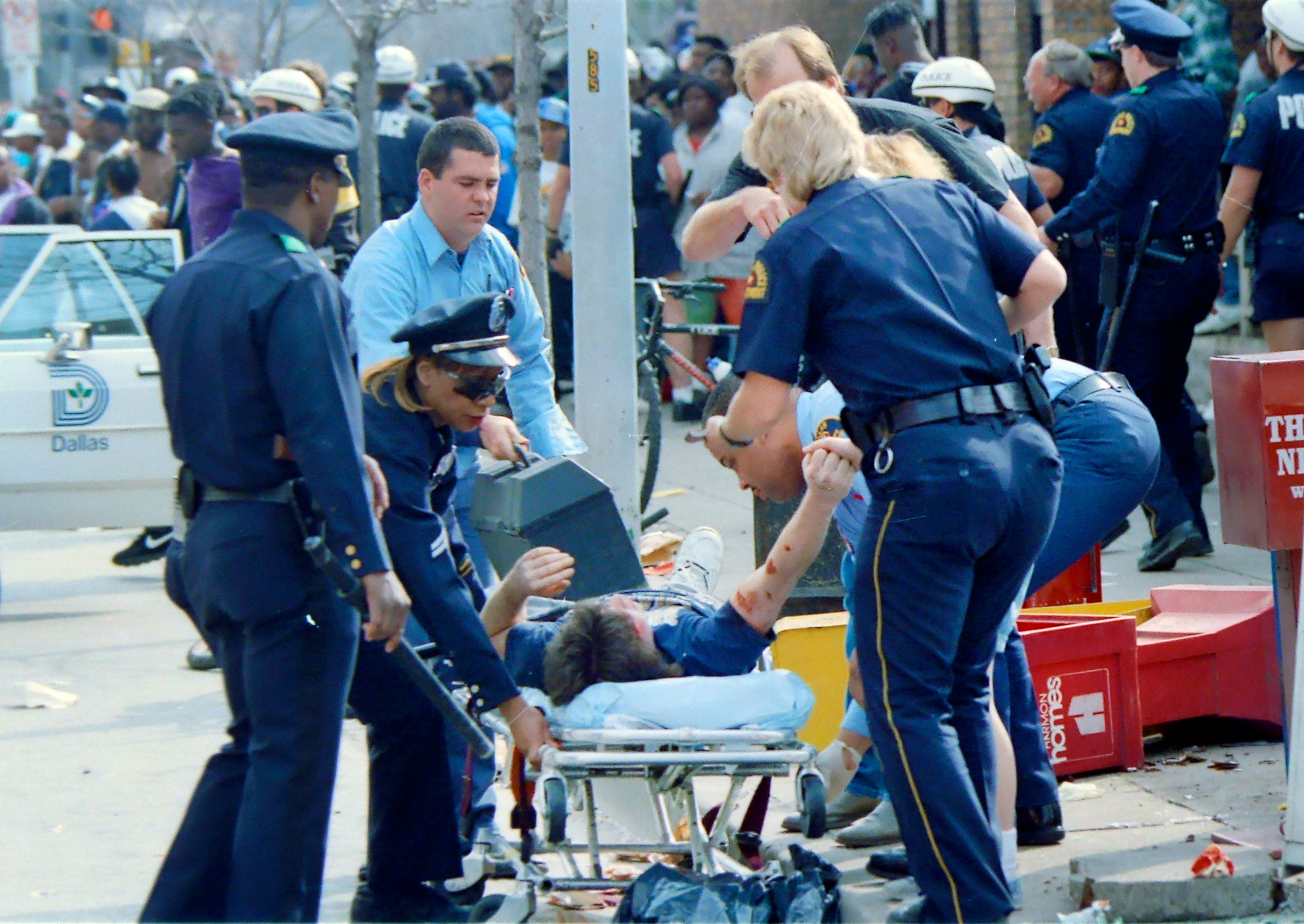 A Dallas Police officers and medics attend to a bloodied teen after violence erupted...