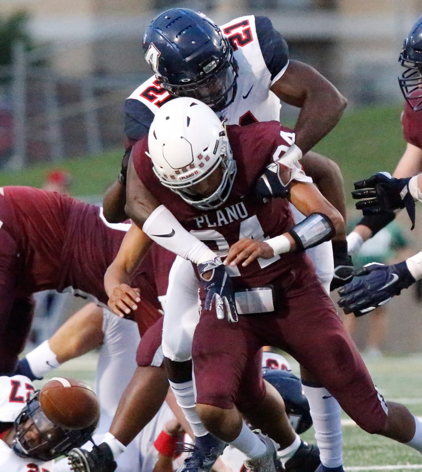 Allen High School defensive lineman Lane Lewis (21) hits Plano High School quarterback...