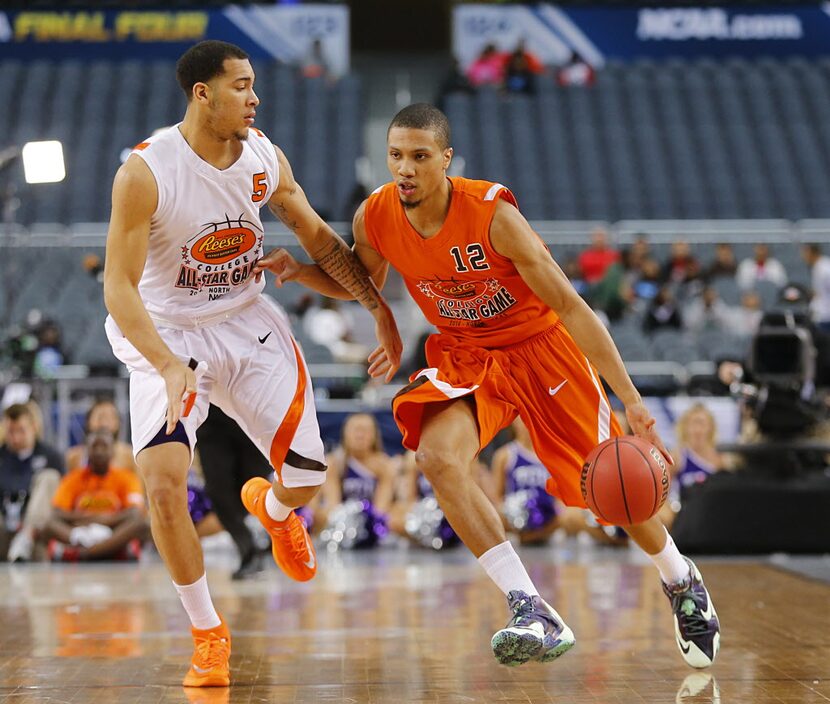 East guard Pendarvis Williams (12) of Norfolk St. drives past West guard Davion Berry (5) of...